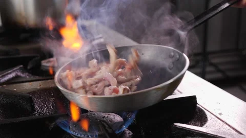 Frying pork meat strips in a pan, tossing and turning them Stock Footage 152608849