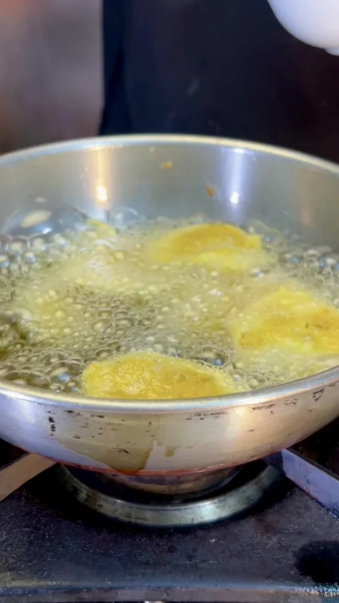 Frying potato pakora made with gram flour or besan in a frying pan. Stock Footage 287306829