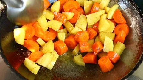 Frying potatoes and carrots in pan Stock Footage 97314701