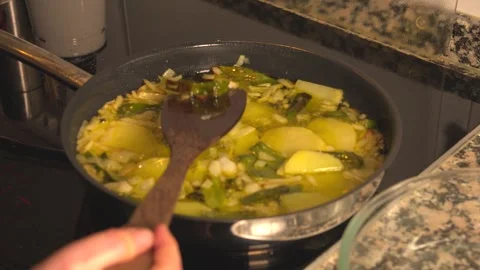 Frying potatoes and vegetables in pan with olive oil Video stock 331314041