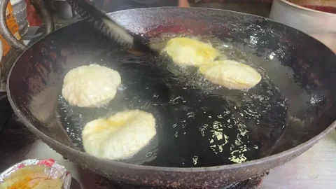 Frying puri in a road side stall in Kolkata, India Stock Footage 316864135