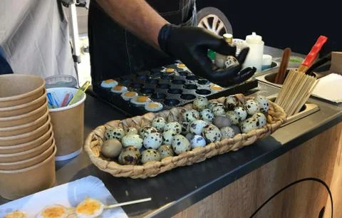 Frying  quail eggs on the stove in the bazaar. Stock Photos