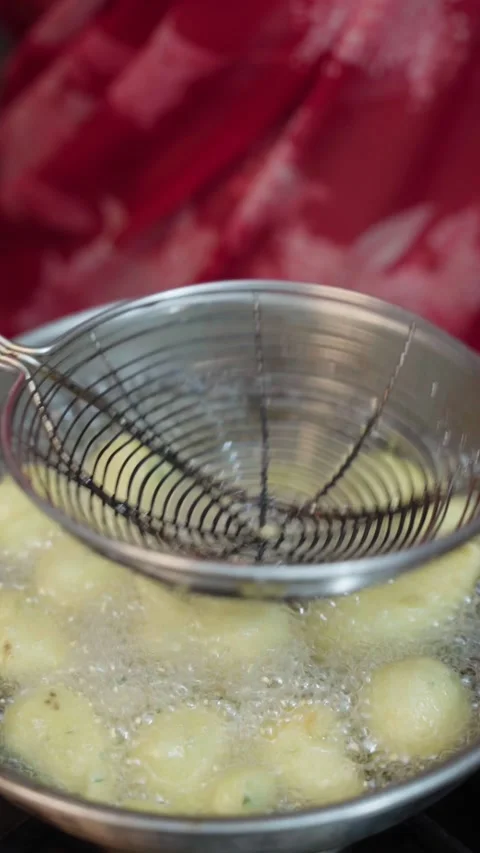 Frying Ram Ladu or ladoo in a small wok, moong dal pakoda frying in a steel wok. Stock Footage 283362291