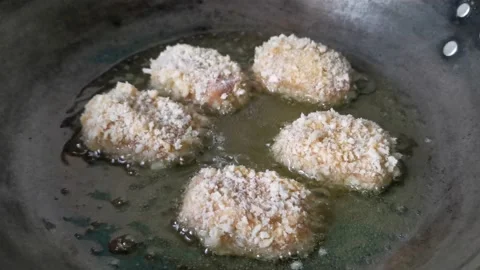 Frying Raw Breaded Chicken Nuggets on a Frying Pan Stock Footage 231360796
