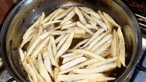 Frying raw cut potatoes in hot oil for french fries Stock Footage 323186961