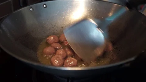 Frying a raw meatball in a hot boiling oil. Stock Footage 127901972