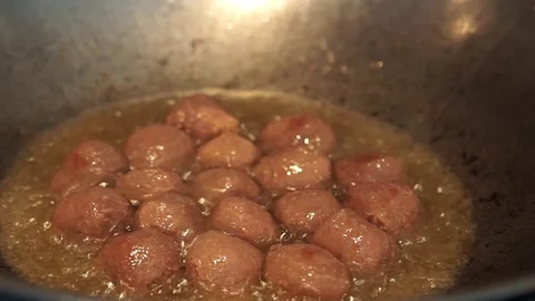 Frying a raw meatball in a hot boiling oil. Stock Footage 127901979
