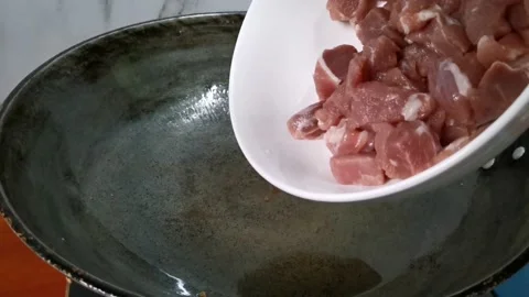 Frying Raw Pork Meat Cubes in a Hot Cooking Oil Stock Footage 235498962