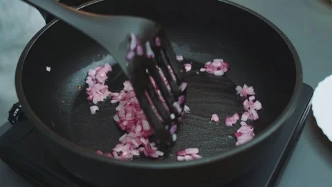 Frying red onions in a pan with olive oil Stock Footage 249856585