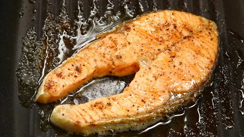 Frying salmon steak in pan, in door  Chiangmai  Thailand Stock Footage 133628663