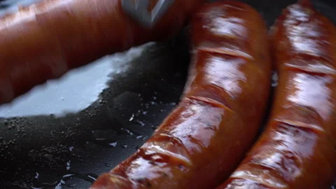 Frying sausages in a hot pan. Close up. Stock Footage 143936065