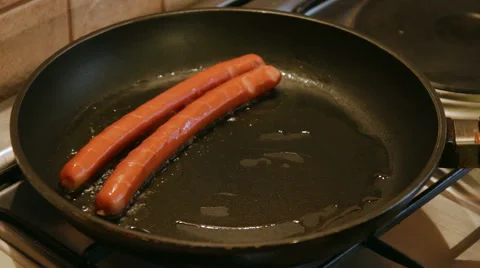 Frying sausages in a pan Stock Footage 56875670