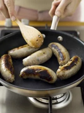 Frying sausages Stock Photos