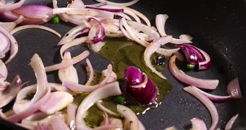Frying sauteing onion green chilli shallots preparing in oil dark non stick.. Stock Footage 267067122