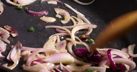 Frying sauteing onion green chilli shallots preparing in oil dark non stick.. Stock Footage 267067126