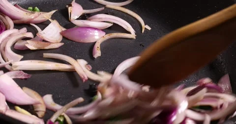 Frying sauteing onion green chilli shallots preparing in oil dark non stick.. Stock Footage 267067133