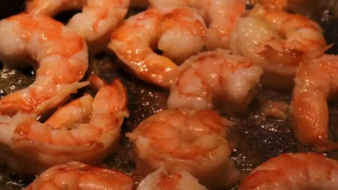 Frying shrimp in hot pan with sizzling oil. Juicy shrimp cooking on skillet with Stock Footage 304759308