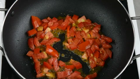 Frying sliced tomatoes in a frying pan Stock Footage 137801575