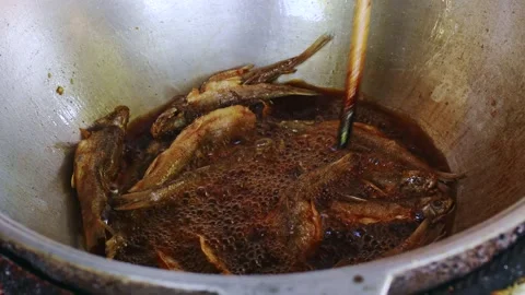 Frying small fish in boiling zigir oil in a deep pan 스톡 동영상 265244891