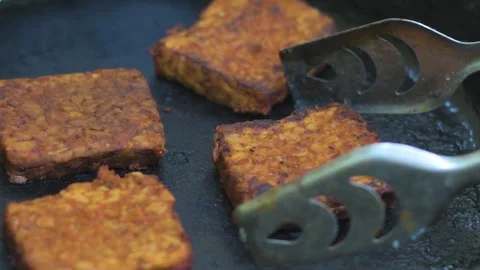 Frying Soya Tempeh on a Cast Iron Pan Without Oil for Healthy Vegan Protein Stock Footage 318568912