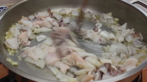Frying squid and onion before making black rice Video stock 260226341