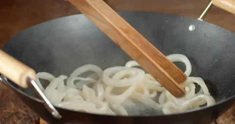 Frying the squid rings in a frying pan. Stockbeeldmateriaal 144580440