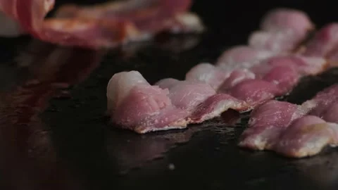 Frying strips of bacon on grill. 動画素材 140329505