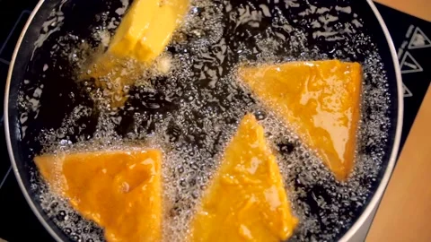 Frying of stuffed bread pieces coated with a layer of Besan Stock Footage 155043666