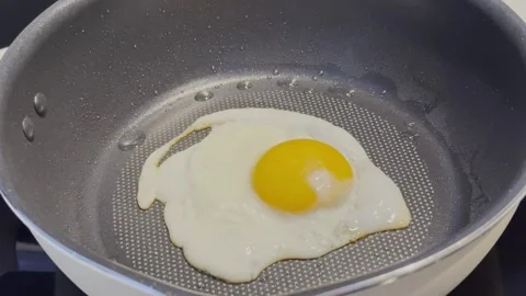 Frying a Sunny Side Up Egg in a Hot Pan Stock Footage 344400868