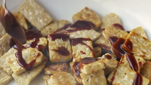 Frying tempeh pieces with a sauce Stock Footage 71680793