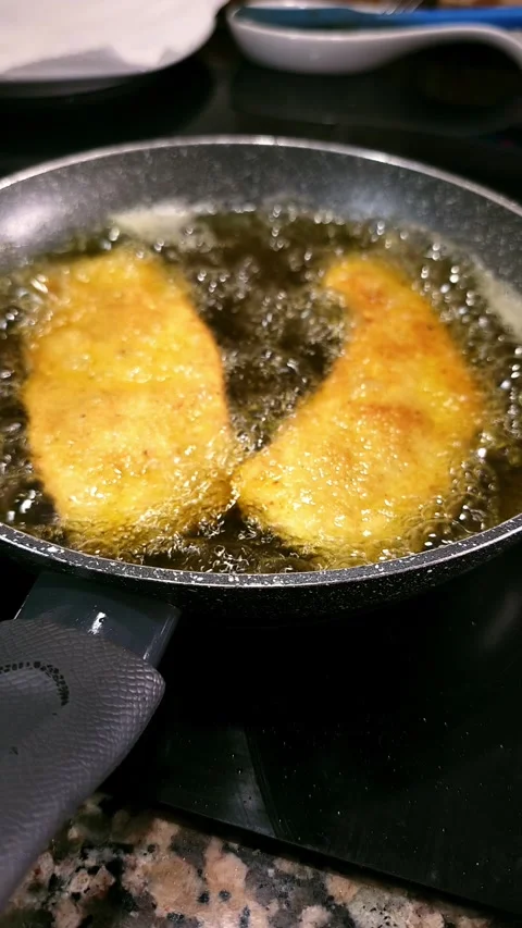 Frying tender breaded chicken fillets on olive oil. Stock Footage 344857903