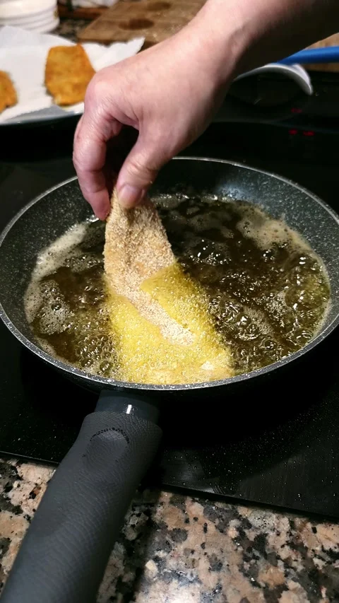 Frying tender breaded chicken fillets on olive oil. Stock Footage 344857916