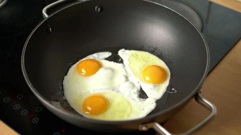 Frying three eggs in a frying pan Stock Footage 302211696