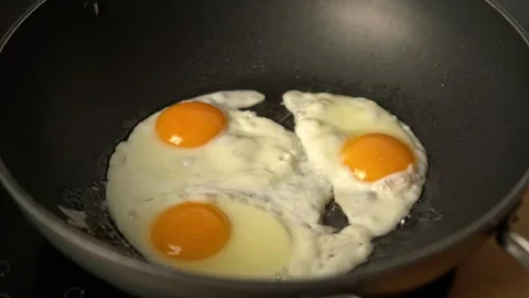 Frying three eggs in a frying pan Stock Footage 302306528