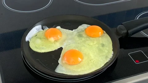 Frying three eggs on pan Stock Footage 130207420