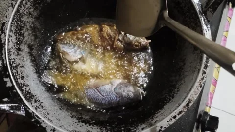 Frying Tilapia Fish in Hot Oil , Traditional Indonesian Cooking Stock Footage 327936349