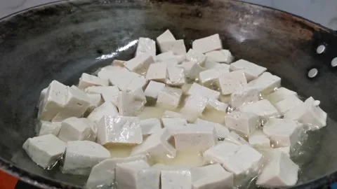 Frying Tofu Cubes in a Pan Stock Footage 157676542