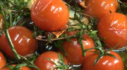 Frying tomatoes, olives and herbs Stock Footage 24634375