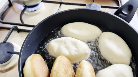 Frying Traditional Stuffed Buns in Hot Oil and Stacking Golden Pastries Stock Footage 330808614