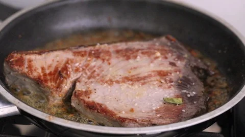 Frying tuna with bay leaf on frying pan Video stock 116735546