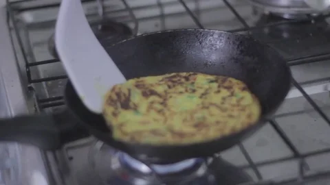 Frying turning and flipping a chickpea omelet Stock Footage 79539625