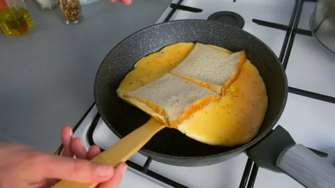 Frying turning fresh bread for sandwich with egg on skillet cooking at home. Stock Footage 318215394