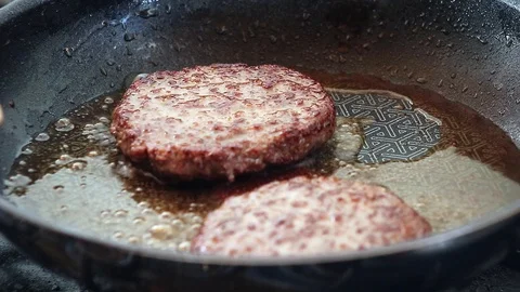 Frying Two Beefburgers in a Non-stick frying pan Vídeos de archivo 92747833