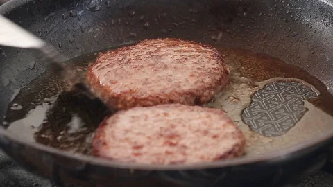 Frying Two Beefburgers in a Non-stick frying pan. Burger flipping and turning Vídeos de archivo 92747845