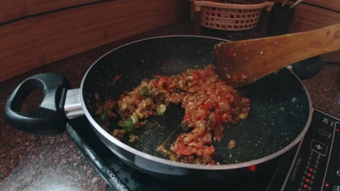 Frying vegetable in pan using electronic stove Stock Footage 282993838