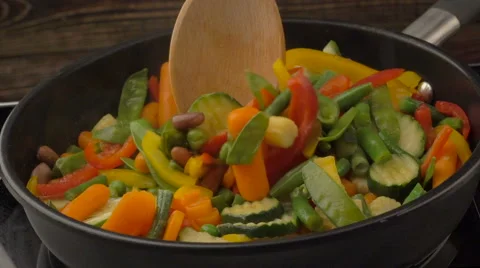 Frying vegetables on black pan Stock Footage 61801675
