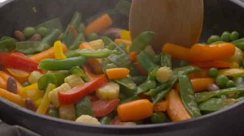 Frying vegetables in black pan Stock Footage 61830335