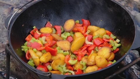 Frying vegetables in a cauldron. Vegetables are fried in a cauldron over a fire Stock-Footage 278464941