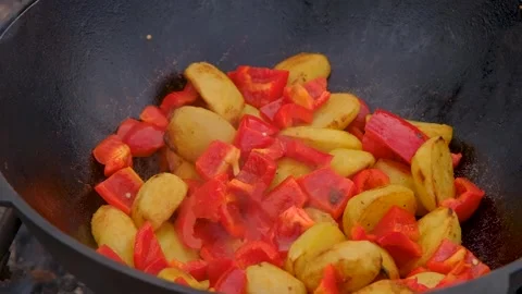 Frying vegetables in a cauldron. Vegetables are fried in a cauldron over a fire Stock Footage 278868316