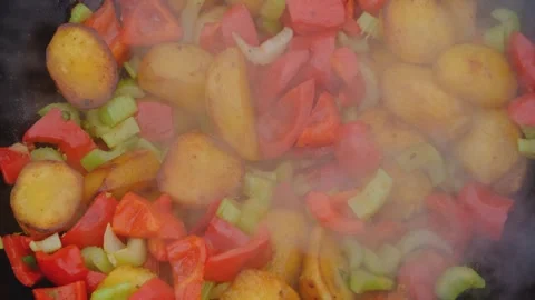 Frying vegetables in a cauldron. Vegetables are fried in a cauldron over a fire Stock Footage 278868819